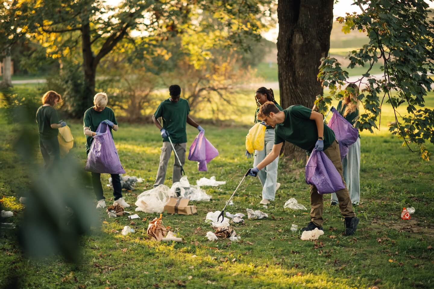 Groupe de volontaires ramassant les déchets présents dans l’herbe