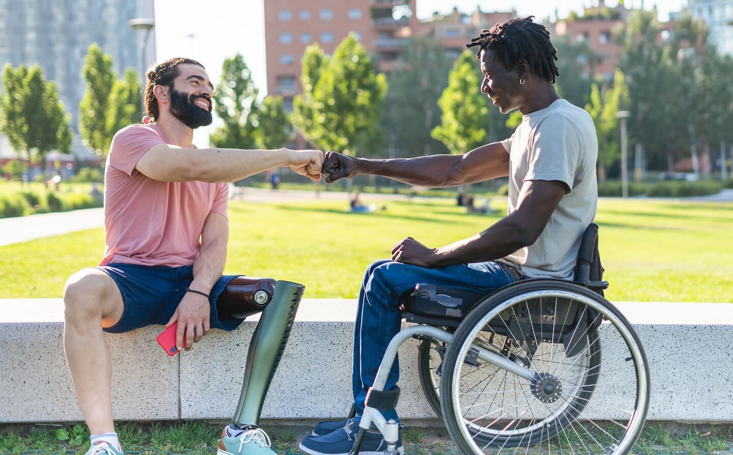 Deux personnes en situation de handicap se tapent dans la main
